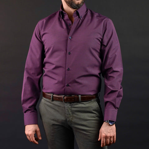 a man wearing a purple shirt and green pants