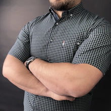 a man with his arms crossed posing for a picture