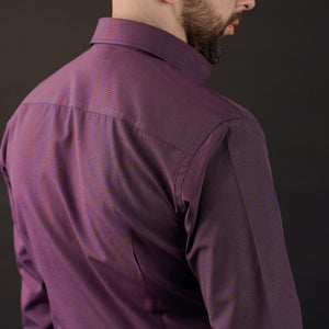 a man with a beard wearing a purple shirt