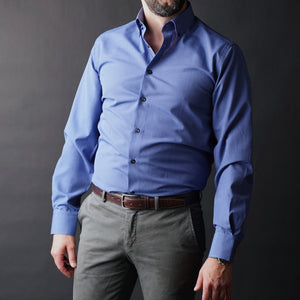 a man wearing a blue shirt and gray pants