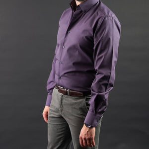 a man in a purple shirt is posing for a picture