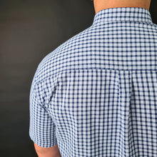 a man wearing a blue and white checkered shirt