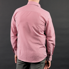 a man in a pink shirt is facing away from the camera