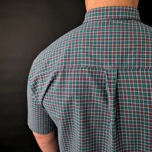 a man wearing a green and red checkered shirt