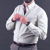 a man adjusting his tie while wearing a dress shirt