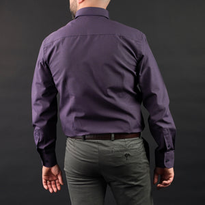 a man wearing a purple shirt and green pants