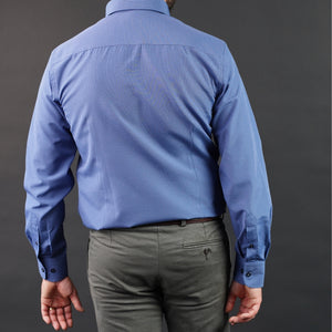 a man in a blue shirt and grey pants