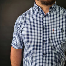 a man wearing a blue and white checkered shirt