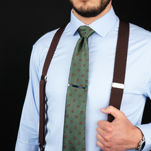 a man wearing suspenders and a green tie